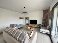sala de estar con sofá y TV en Casa Lamaghjone - Villa T4 avec piscine chauffée à 3,5km de la mer, en Aléria