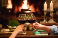 Dos personas sosteniendo copas de vino frente a una mesa. en Hotel Estalagem St. Hubertus, en Gramado