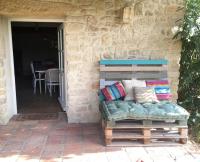 a couch sitting outside of a stone house at Gite des amis Domaine de Mas Caron in Caromb