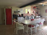 a kitchen with a table and chairs and a red refrigerator at Gite des amis Domaine de Mas Caron in Caromb