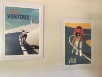 two framed posters of a woman riding a bike at Gite des amis Domaine de Mas Caron in Caromb