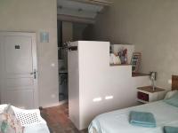 a bedroom with a bed and a white refrigerator at Gite des amis Domaine de Mas Caron in Caromb