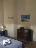 a bedroom with a bed and a dresser and a painting at Gite des amis Domaine de Mas Caron in Caromb