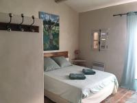 a bedroom with a large white bed in a room at Gite des amis Domaine de Mas Caron in Caromb