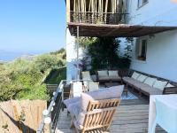 a porch with chairs and a couch on a balcony at Casa Costa in Barbaggio