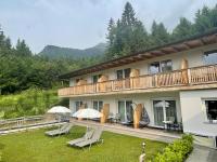 a building with chairs and umbrellas on a yard at Sweet Cherry - Boutique &amp; Guesthouse Tyrol in Innsbruck