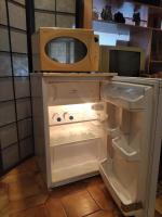 einen offenen Kühlschrank mit einer Mikrowelle darüber in der Unterkunft Charmante chambre d&#39;hôte in Sigean