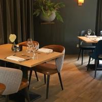a restaurant with tables and chairs with wine glasses at Adorable two bedroom bungalow C7 next to hotel. in Garderen