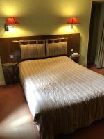 a large bed in a hotel room with two lamps at LE CABOUILLET in LʼIsle-Adam