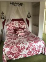 a bedroom with a bed with a red and white blanket at LE CABOUILLET in LʼIsle-Adam
