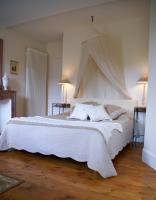 a bedroom with a large bed with white sheets and pillows at Gîte de la corgette in Saint-Romain