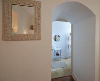 a hallway with a mirror on a white wall at Gîte de la corgette in Saint-Romain
