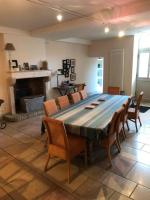 a dining room with a table and chairs and a fireplace at Gîte de la corgette in Saint-Romain