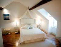 a bedroom with a white bed with two night stands at Gîte de la corgette in Saint-Romain