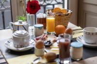 einem Frühstückstisch mit Eiern und einem Korb mit Orangen in der Unterkunft Hôtel &amp; Espace Bien-être La Maison du Lierre in Biarritz