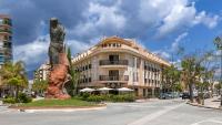 un edificio con una estatua en medio de una calle en Hotel Galicia, en Fuengirola