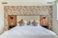1 dormitorio con 1 cama blanca grande con cabecero de madera en Zenitude Hotel la Valadière, an Ascend Collection Hotel, en Montpellier