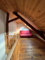 a room with a red couch in the attic at Townhouse The Granary Bourg d’Oisans in Le Bourg-dʼOisans