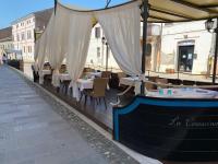 un restaurante con mesas y sillas bajo un dosel en Locanda La Comacina, en Comacchio