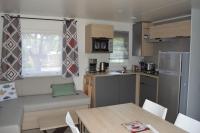 a small kitchen with a table and a couch in a kitchen at Mobil home neuf en Bretagne sud in Guérande