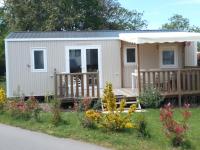 a tiny house with a porch and a deck at Mobil home neuf en Bretagne sud in Guérande