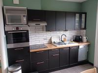 a kitchen with black cabinets and stainless steel appliances at La Casa in Saint-Brieuc