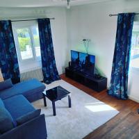 a living room with a blue couch and a tv at La Casa in Saint-Brieuc