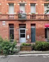 a brick building with a blue door and a balcony at Le Duplex au centre de Toulouse - Self check In in Toulouse