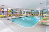 Una piscina en una habitación de hotel con mesas y sillas. en Hampton Inn Boston &#47; Marlborough, en Marlborough