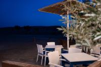 a table and chairs and an umbrella on the beach at Prasonisi Light House Boutique Hotel in Prasonisi
