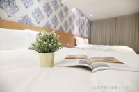 a book on a bed with a vase of flowers at Talmud Hotel Yizhong in Taichung