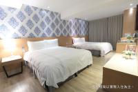 a hotel room with two beds in a room at Talmud Hotel Yizhong in Taichung