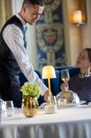 a man and woman sitting at a table with a glass of wine at Hôtel Royal in Évian-les-Bains