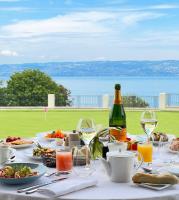 a table with plates of food and glasses of wine at Hôtel Royal in Évian-les-Bains