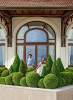 a man and a woman sitting in a bush garden at Hôtel Royal in Évian-les-Bains