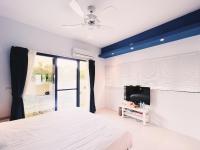 a bedroom with a bed and a flat screen tv at Qixingtan Xinghai B&amp;B in Dahan