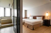 a hotel room with two beds and a bathroom at Beitou Sweet Me Hot Spring Resort in Taipei