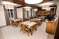 une salle à manger avec des tables et des chaises en bois dans l'établissement Újhuta Kastélyszálló, à Háromhuta