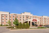Un gran edificio de ladrillo con un cartel en él. en Hampton Inn &amp; Suites West Bend, en West Bend