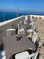 特罗佩阿La Locanda del Convento的一组桌子和椅子,背景是海洋