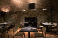 um restaurante com mesas e cadeiras e uma parede de tijolos em Hotel Villa Montegranelli em Gubbio