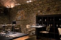 um restaurante com mesas e cadeiras e uma parede de pedra em Hotel Villa Montegranelli em Gubbio