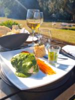 un plato de comida en una mesa con copas de vino en Estancia Villa Maria, en Ezeiza
