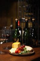 una mesa con copas de vino, queso y botellas de vino en Estancia Villa Maria, en Ezeiza