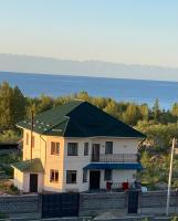 a large white house with a green roof at Maksat house in Tossor