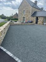 a gravel driveway in front of a stone house at Les Ecuries in Saint-Maurice-en-Cotentin