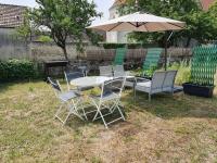 a table and chairs and an umbrella in a yard at Cosy Billy - Appartement de charme in Billy