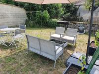 a group of chairs and a table and an umbrella at Cosy Billy - Appartement de charme in Billy
