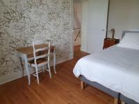 a bedroom with a bed and a desk with a chair at Cosy Billy - Appartement de charme in Billy