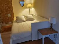 a white bed in a room with a lamp and a table at Cosy Billy - Appartement de charme in Billy